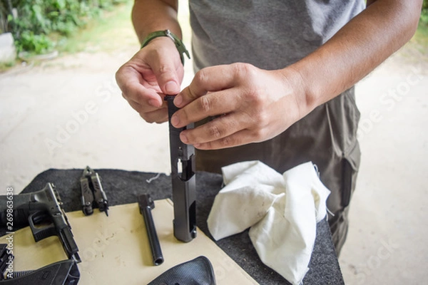 Obraz man cleaning gun
