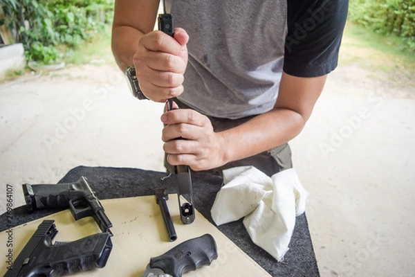 Obraz man cleaning gun