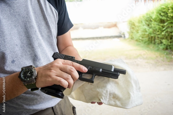 Obraz man cleaning gun