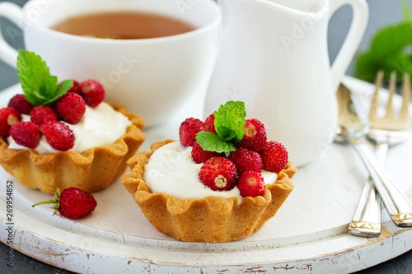 Fototapeta Wild strawberry tartlets with cream filling. delicious summer fruit mini tarts