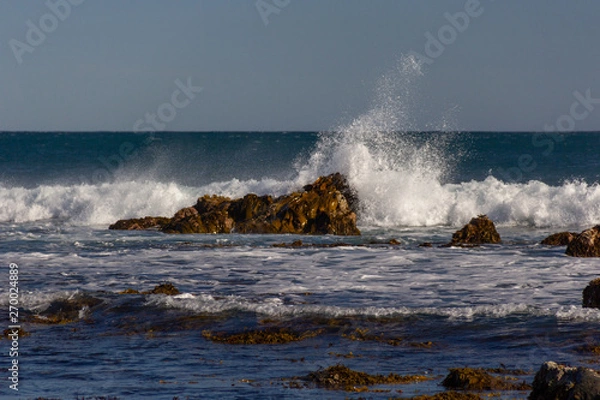 Fototapeta rocks with waves breaking over them