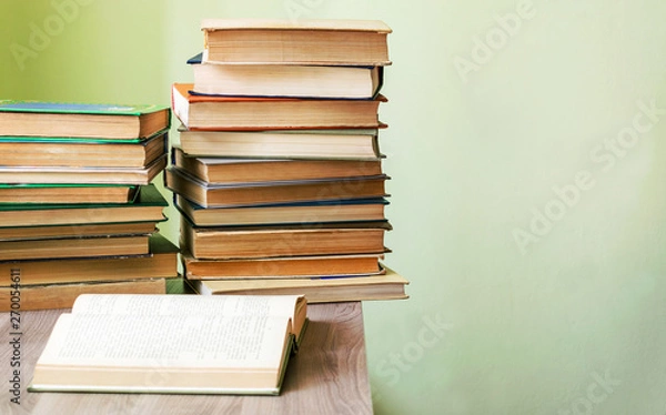 Obraz On the table a stack of old books. Preparation for exams at the University. Reading literature.