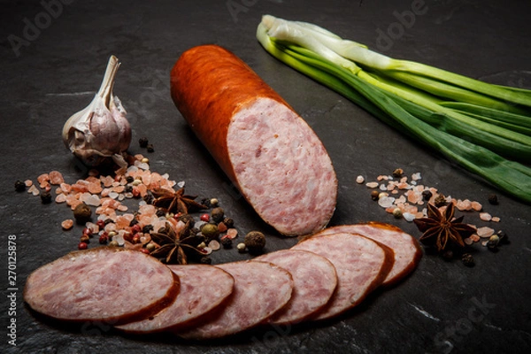 Obraz big chunk of smoked ham sausage with garlic and green onion