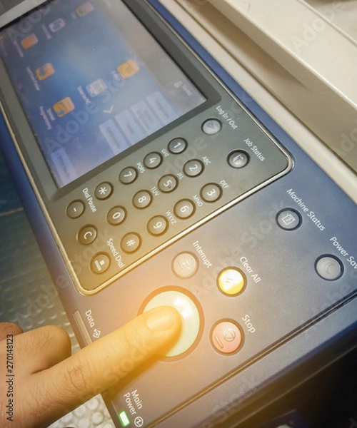 Fototapeta Hand press button on panel of printer, Finger pressing the start button on a multifunction printer.