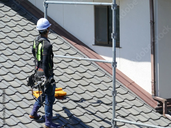 Obraz 屋根の上で作業をする男