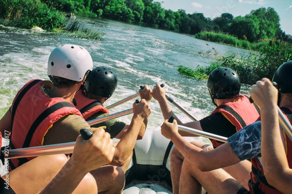 Fototapeta  Rafting team , summer extreme water sport.  Group of people in a rafting boat, beautiful adrenaline ride down the River. Back view. POV