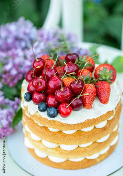 Fototapeta Homemade summer biscuit cake with cream and fresh berries In the garden Lilac Soft focus