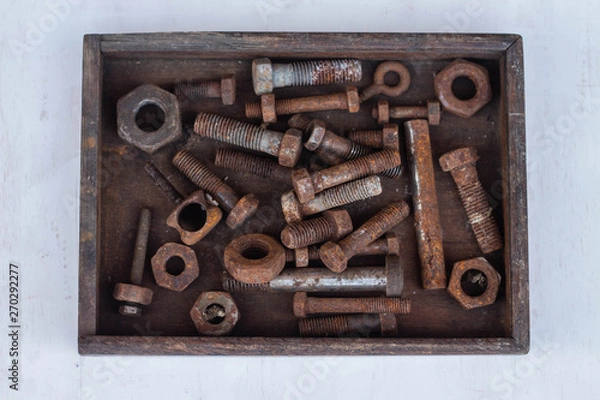 Fototapeta Background from old rusty bolts, screws, nuts, screws, brackets, various metal details. Rusty set of hand tools. White background. Vintage tools. Artisan work concept.