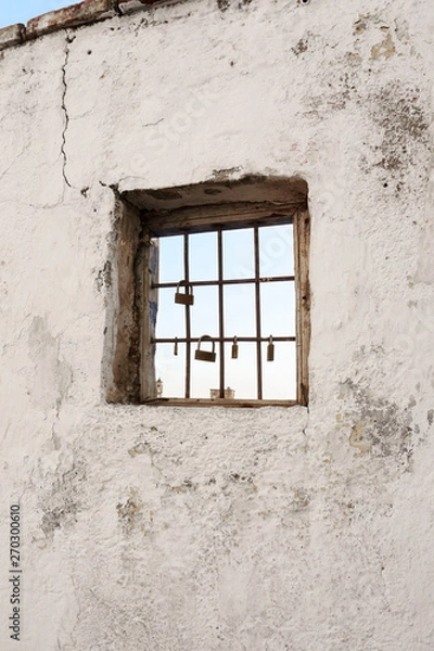 Fototapeta The sky seen through the window with bars of a ruined house