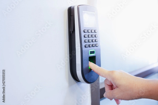 Fototapeta The employee scanning fingerprint to record working time