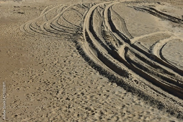 Fototapeta Four wheel drive tyre marks in soft sand with copy space background