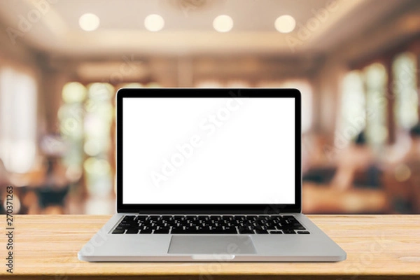 Fototapeta Blank screen laptop computer on wood table top with blur cafe restaurant with abstract bokeh light defocused background