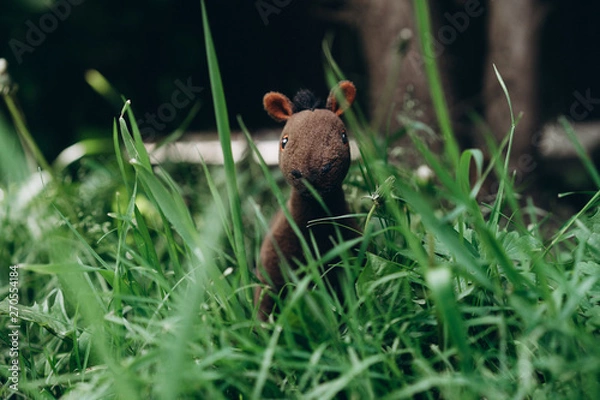 Fototapeta plush toy horse grazing in the grass