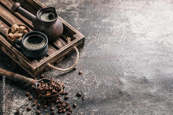 Fototapeta Coffee on wooden tray with coffee beans on dark textured background. Top view with copy space. Background with free text space.