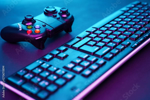 Fototapeta Keyboard and joystick on violet table background.