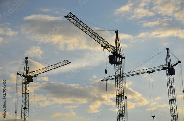 Fototapeta Construction crane near the building under construction. Close up of a construction crane. Self-erection crane. Construction site