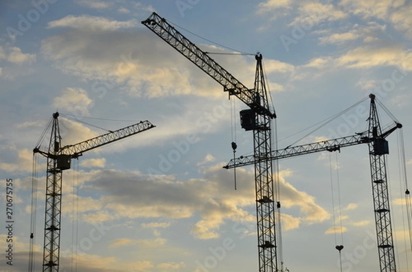 Fototapeta Construction crane near the building under construction. Close up of a construction crane. Self-erection crane. Construction site