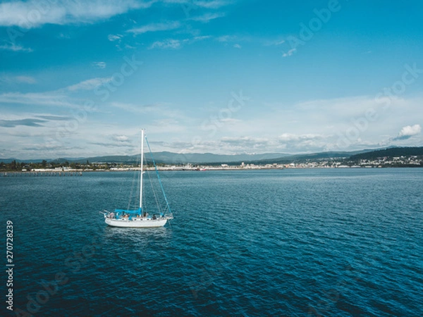 Fototapeta Overhead view of a Sailboat overlooking a Seaside City