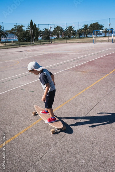 Fototapeta young boy playing with a skateboard