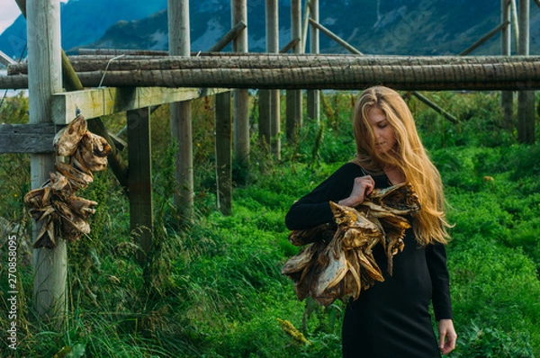 Obraz Girl in black dress with bundle of dried fish heads