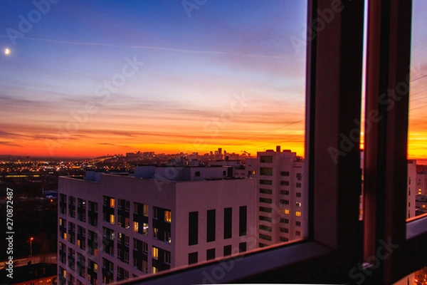 Fototapeta City on Sunset from close windows.City skyline in the dusk. Amazing panoramic view of modern city from high rise building
