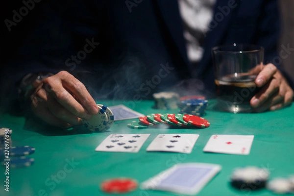 Fototapeta professional poker game. Green poker table with two games. poker player makes a bet by throwing chips on the table