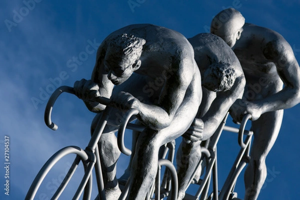 Obraz Trois cyclistes en compétition, détail d'une immense sculpture