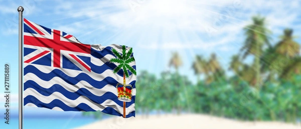 Fototapeta Waving British Indian Ocean Territory flag in the sunny blue sky with summer beach background. Vacation theme, holiday concept.
