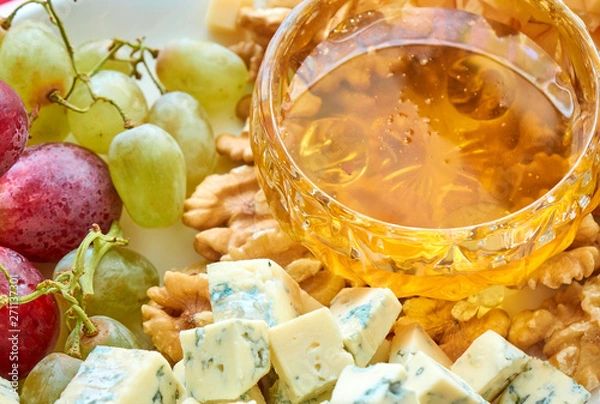 Fototapeta Cheese, grapes, walnuts and honey gourment assorted