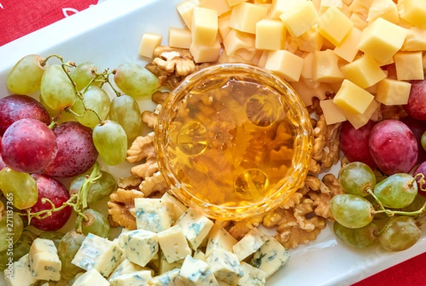 Fototapeta Cheese, grapes, walnuts and honey gourment assorted
