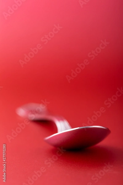 Fototapeta Isolated spoon in red ambient for a food concept