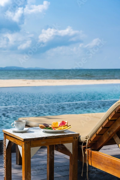 Fototapeta Vertical photo of delicious breakfast on the peaceful beach