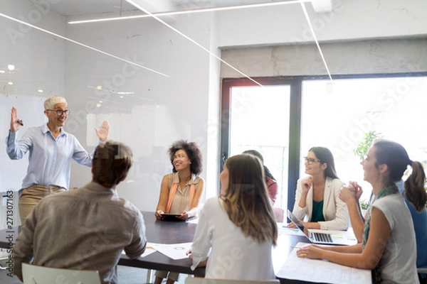 Fototapeta Group of business people working and communicating in office together with colleagues