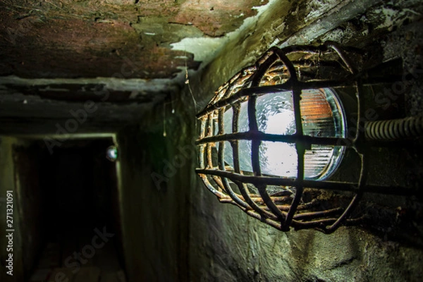 Fototapeta Shabby walls and a lantern in a prison corridor in the most terrible prison in Russia
