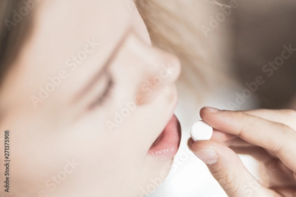 Fototapeta medicine, health care and people concept - close up of woman taking in pill