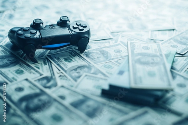 Obraz Concept of gaming addiction. Close up photo of gamepad on the money background.