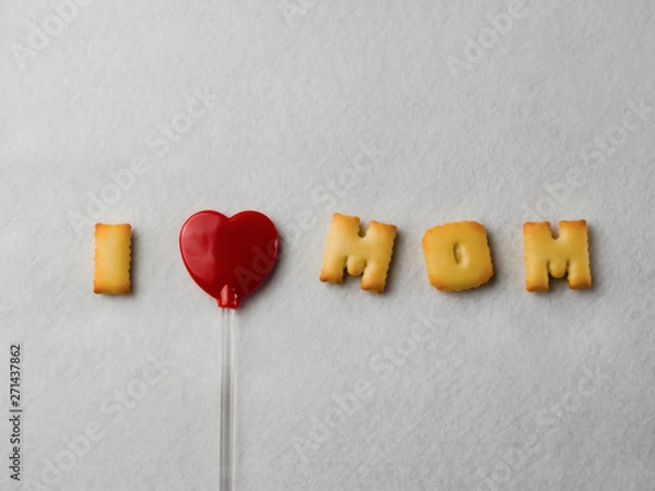 Fototapeta Biscuits with letter shapes And a red heart-shaped lollipop, arranged in a message “I Love Mom” For Mother's Day