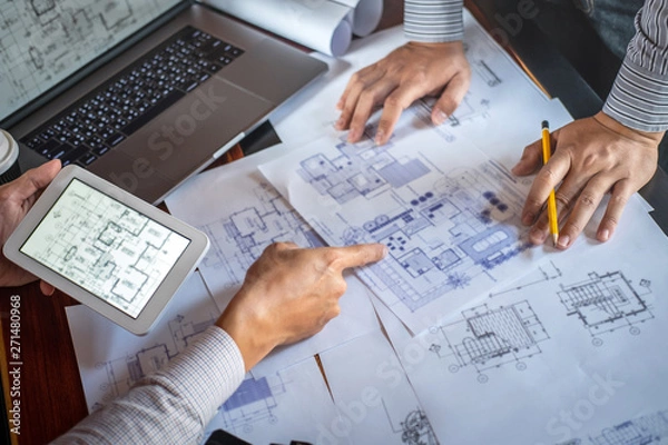 Obraz Construction engineering discussing a blueprint while checking information