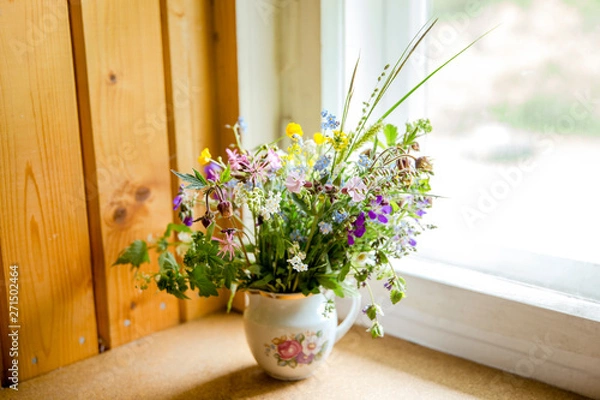 Obraz Vintage style flower bouquet made of wild flowers found in forest and meadow, standing in old cream jug on window sill, summers in grandma`s house concept. Northern Europe.