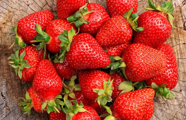 Fototapeta Red and ripe large strawberries on a wooden surface. Close-up. Harvest.