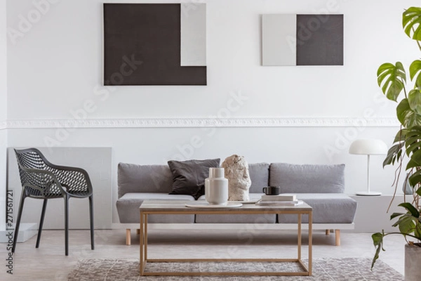 Fototapeta Knick knacks on elegant coffee table in front of grey sofa in luxury living room interior