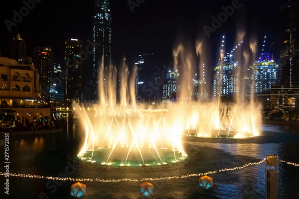 Obraz Dancing fountains in focus night background selective focus. Shallow depth of field.