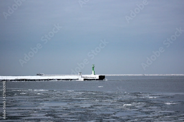 Obraz winter port, snowed breakwater and green lighthouse