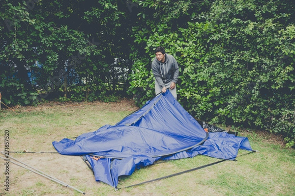 Obraz Campers setting  up a nylon tent in a Camping holidays close to Bristol, England.
