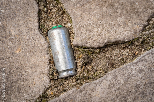 Fototapeta Closeup of Bullet casing lying on a road