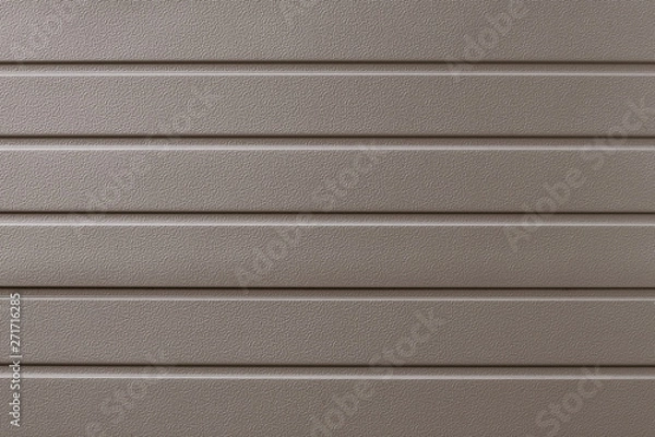 Fototapeta Light brown metallic ribbed surface. Abstract pattern. Beige metal backdrop. Gold industrial background of steel plate. Metalline wall siding, cladding. Striated background, fence with shine. 