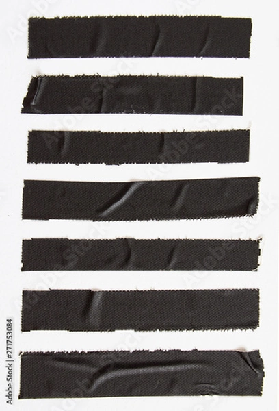Fototapeta Crumpled pieces of black matte cloth gaffer tape on white paper background.