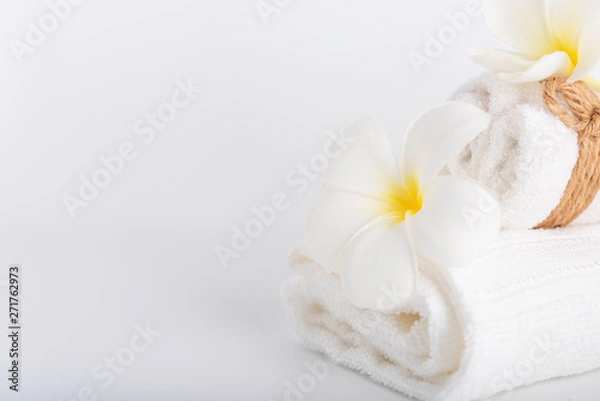 Fototapeta White rolled towels decorate with Frangipani flowers spa object on white background