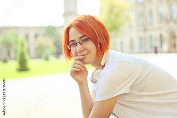 Fototapeta Exchange student , holding notebook, thinking on project.  walking and talking each other in a campus at sunset with a warm light