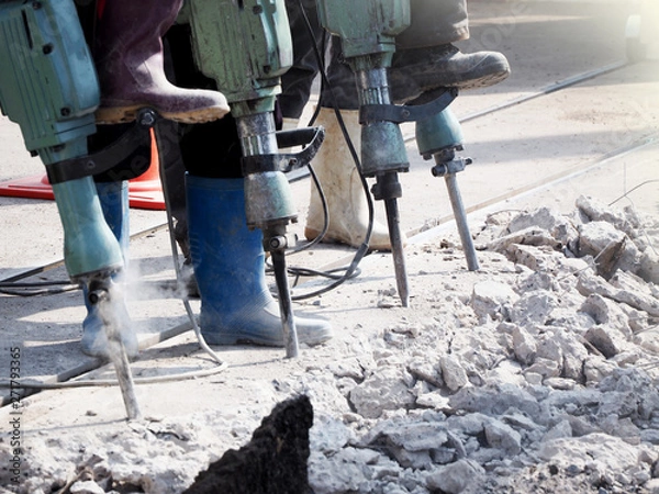 Fototapeta A Worker man drilling in concrete on a construction site